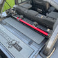 Image of a Jeep Wrangler JKU with a Diabolical, Inc. Slipstream security enclosure and foam deck pads with the Rail Rack accessory mount installed with a HiLift Jack.
